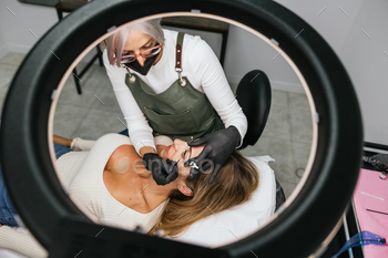 Professional beautician applying eyelash extensions