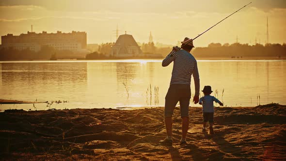 A Father and His Son on Fishing Together - a Man Holding the Rod and the Happy Boy Walking on the