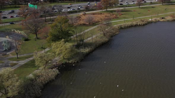 aerial orbit, counterclockwise as seagulls fly low over Meadow Lake. The Grand Central Parkway is in