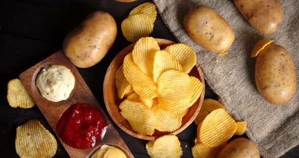 Chips with Different Sauces and Fresh Potatoes Slowly Rotate. 