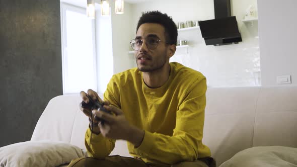 African Boy Plays with a Joystick at Home