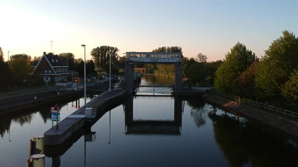 Small river water lock during sunset in drone ascending view
