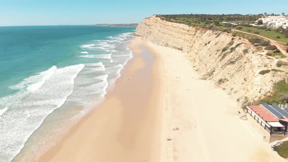 Sandy beach of Porto de Mós by rocky cliff in Lagos coast, Algarve, Portugal