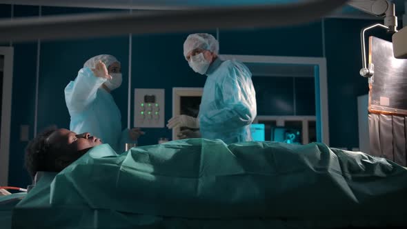Two Surgeons Discuss Patient Treatment in Operating Room
