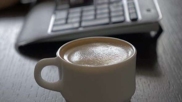 Doing job selective focus on  coffee cup and keyboard 4K 2160p UHD footage - Typing on keyboard and 