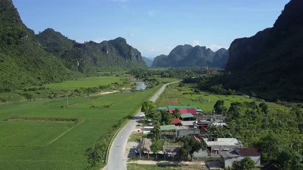 Close Flight Over Country Road Running in Valley Among Hills