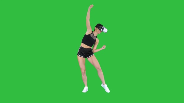 Happy smiling young girl using VR headset glasses playing