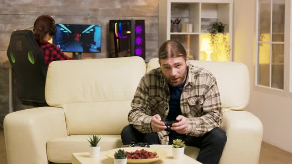 Angry Man After Losing at Online Video Games Sitting on Couch