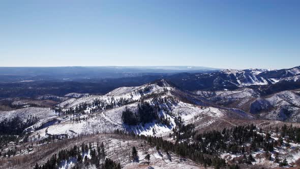 High altitude drone aerial view of mountains and snowy valleys in NM, US