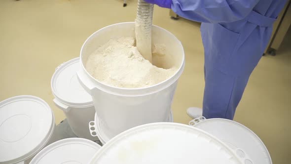 Worker Blowing Drug Material Powder in the Containers at Pharmaceutical Production. Manufacturing