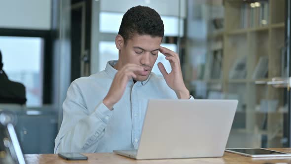 Tired Young African Man Having Headache in Office