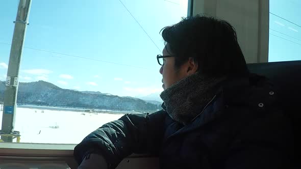 Asian Man Travel By Train On Winter