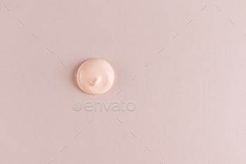 A round sample of liquid foundation powder . Delicate texture of foundation in a natural tone.