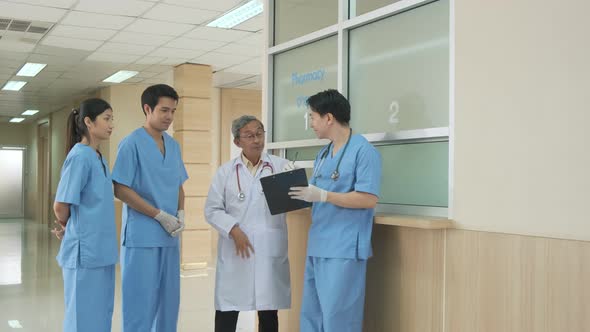 Team of asian doctor nurse consult together on patients file at hospital.