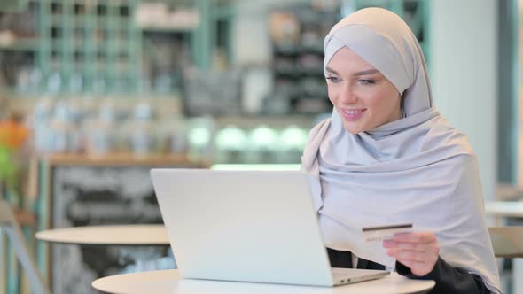 Arab Woman Making Online Payment on Laptop with Credit Card 