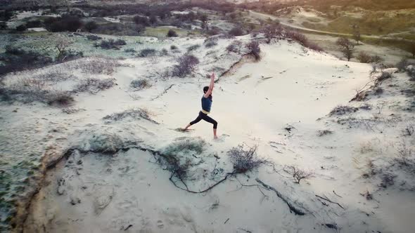 Silhouette of a Woman Practicing Yoga in the Dunes at Sunrise