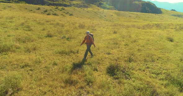 Flight Over Backpack Hiking Tourist Walking Across Green Mountain Field