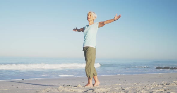 Senior Caucasian woman enjoying time at the beach with sea in the background