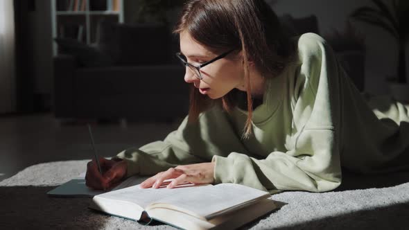 Pleasant Woman Writing Notes While Reading Book