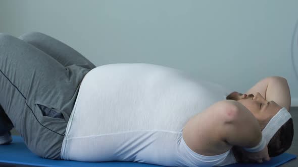 Motivated Heavy Man Doing Crunches Effort, Burning Calories, Abdominal Exercises