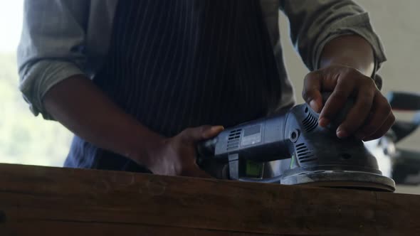 Carpenter polishing wood with machine 4k