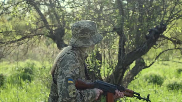 Ukrainian Female Soldier Armed with an Assault Rifle Patrols a Combat Zone