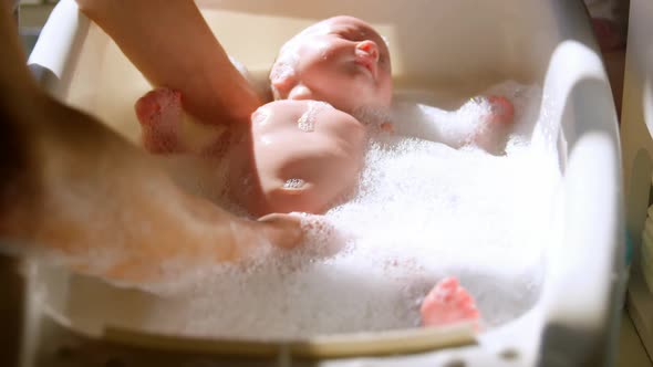 Mother giving her baby boy a bath in bathroom 4k