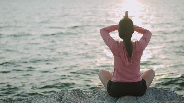 Athletic Asian female sitting in meditation pose position medicine yoga pranayama balance.