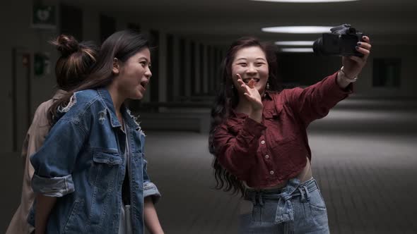 Asian female friends bloggers creating content for social media while making a video with a camera.