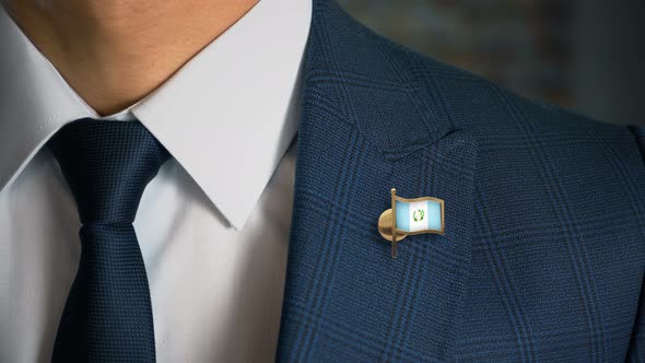 Businessman Walking Towards Camera With Country Flag Pin Guatemala