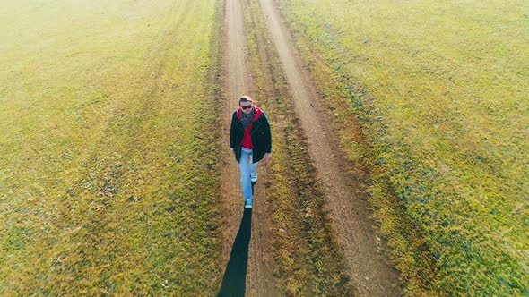 Aerial Video of a Man Walking on the Road in Autumn