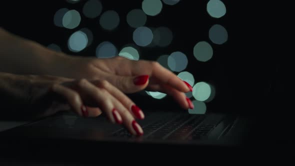 Female Hands is Typing on a Laptop at Night