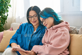 Bonding moment: mother and daughter engrossed in phone