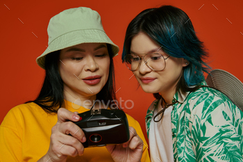 Shared screen: mother and daughter engrossed in camera