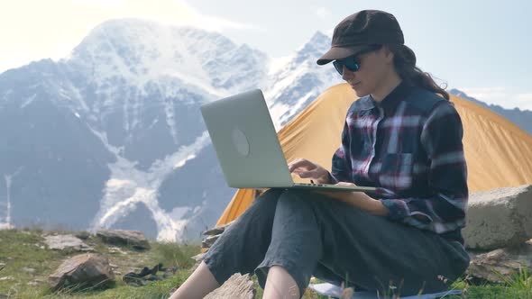 Lady Tourist Types on Laptop Sitting on Hill Top Grass