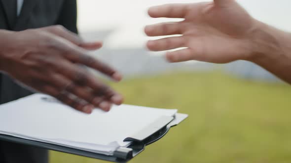 Close Up of Technician and Businessman Shaking Hands Outdoors
