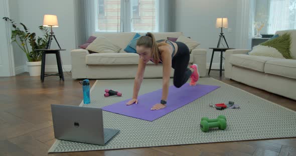 Sportswoman Doing Morning Fitness Exercises with Help of Her Instructor Online on Laptop. Healthy