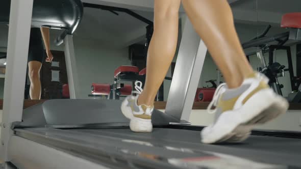Young Athletic Woman is Running on the Treadmill
