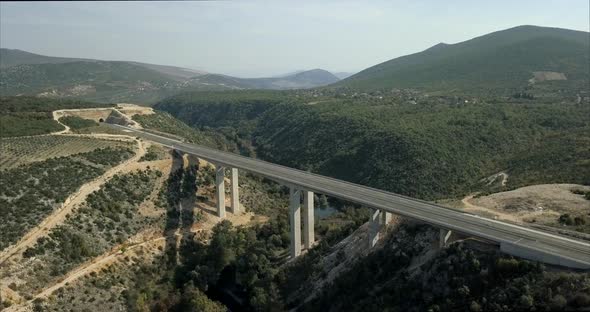 Aerial footage of a highway bridge in Bosnia and Herzegovina with mountains and hills in the distanc