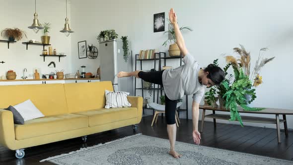 A Young Indian Woman Does Yoga Meditation At Home, Does A Balance Exercise, Stands On One Leg