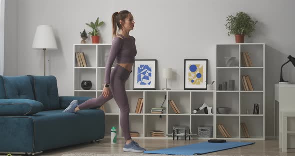 Young Woman with Ponytail Is Doing Squats at Home Training Alone in Living Room at Weekend Healthy