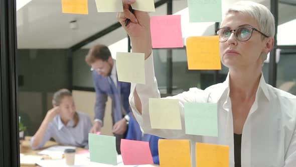 Businesswoman Looking To Sticky Notes Thinking Deeply in Office Meeting Room