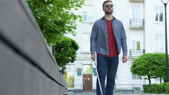 Young Blind Man with Using Safety Stick for Walking Alone Outdoors