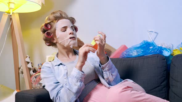 Woman sitting on the couch with trash and garbage around her.