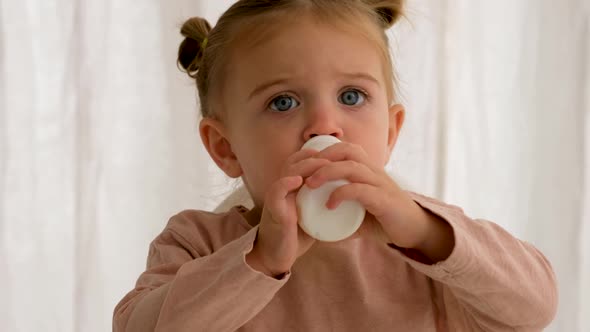 Child Drinks Milk From a Bottle