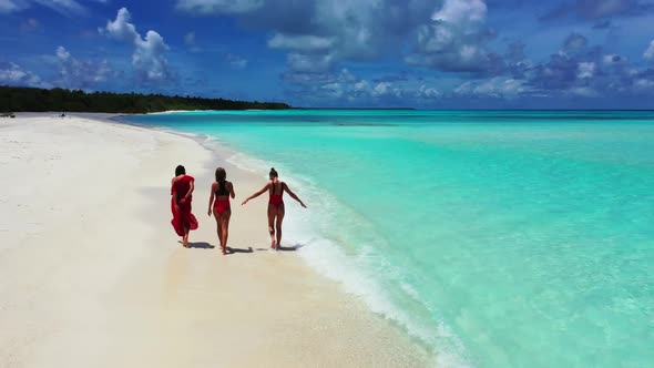 Beautiful ladies relaxing on luxury lagoon beach wildlife by aqua blue sea and clean sandy backgroun