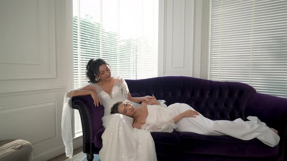 4K Portrait of Asian woman lesbian gay couple in wedding dress resting together in the room