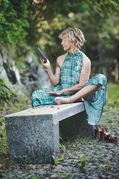 Woman reads from ebook on bench