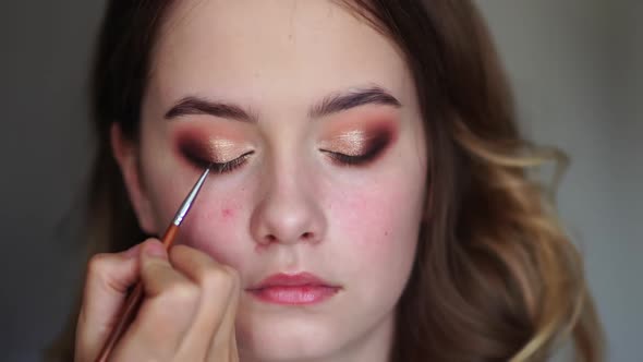 Makeup Artist Paints Eyelids on a Model Girl