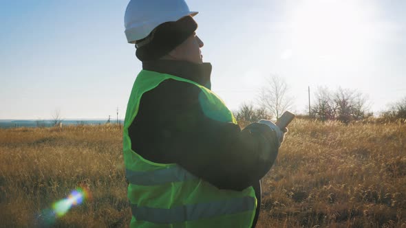 Mature Engineer Working on Smartphone with Satellite Dish Telecom Network on Telecommunication Tower